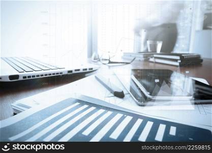 business documents on office table with smart phone and digital tablet and graph business diagram and man working in the background with business graph diagram