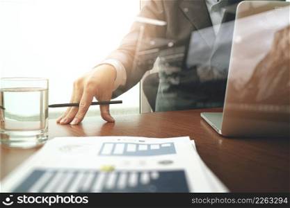 business documents on office table with smart phone and digital tablet and graph business and man working in the background