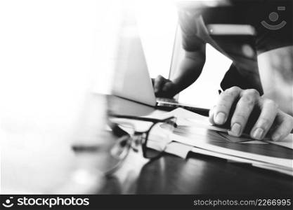 business documents on office table with smart phone and digital tablet and graph business with social network diagram and man working in the background,black and white