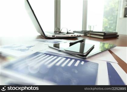 business documents on office table with smart phone and digital tablet as work space business concept