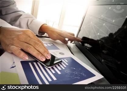 business documents on office table with smart phone and digital tablet with laptop computer and man working in moment