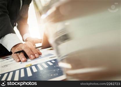 business documents on office table with smart phone and laptop computer and graph business with digital layer effect and man working in the background