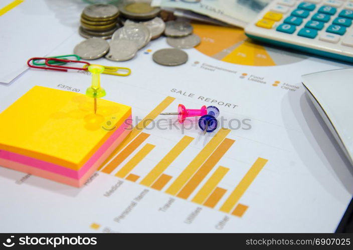 business documents on table with mouse computer and coins and graph financial diagram.