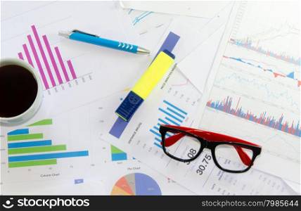 business documents over papers with numbers and charts. View from above