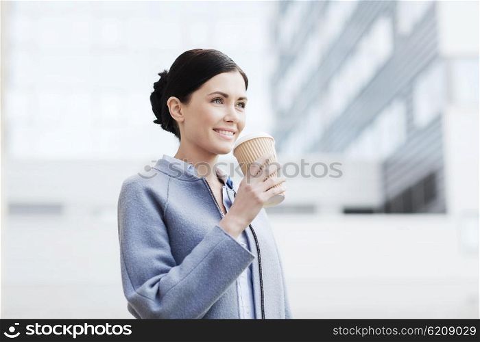 business, drinks, leisure and people concept - smiling woman drinking coffee over office building in city