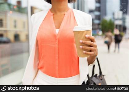 business, drinks, lifestyle and people concept - close up of young african american businesswoman with coffee cup in city
