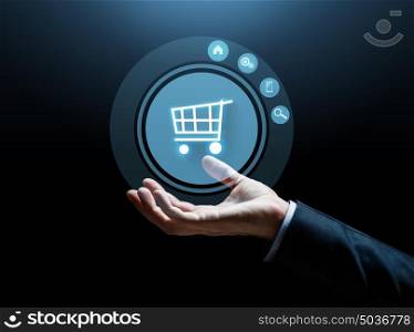 business, e-commerce and people concept - close up of businessman hand with shopping cart over dark background. close up of businessman hand