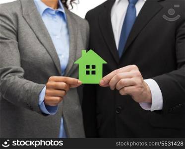 business, eco and real estate concept - businessman and businesswoman holding green house