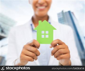 business, eco and real estate concept - closeup picture of woman hands holding green house