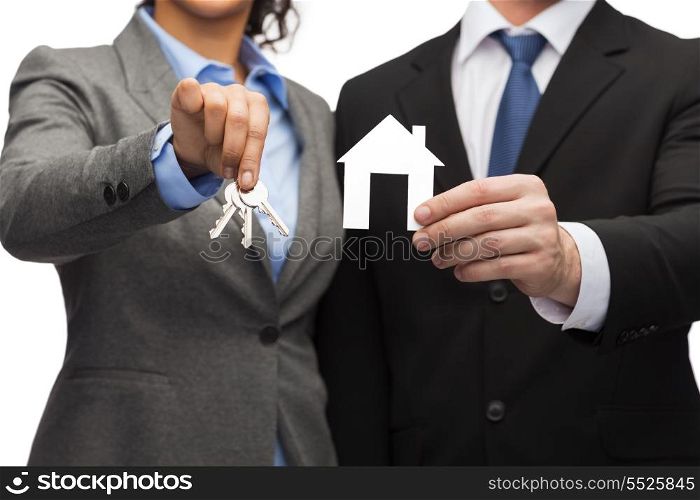 business, eco, real estate and office concept - businessman and businesswoman holding white paper house and keys