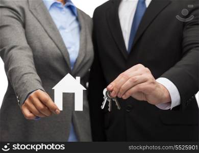 business, eco, real estate and office concept - businessman and businesswoman holding white paper house and keys