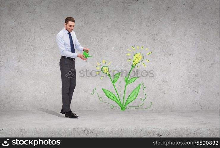 business, ecology and office concept - handsome businessman with green watering can showering flower with light bulbs