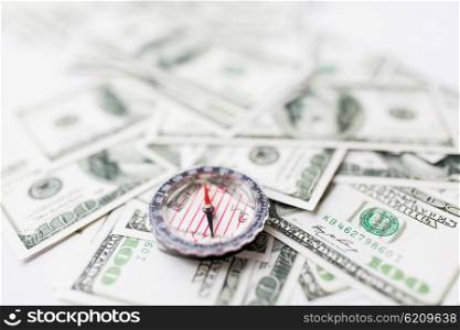business, economy, finance and investment concept - close up of compass and dollar money