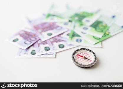 business, economy, finance and investment concept - close up of compass and euro money on table