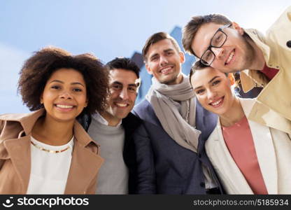 business, education and corporate concept - international group of happy smiling people or friends on city street. group of happy people or friends on city street