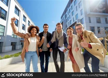 business, education and corporate concept - international group of people showing thumbs up on city street. group of people showing thumbs up in city