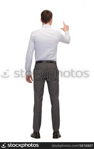 business, education and office concept - businessman or teacher pointing on something from back