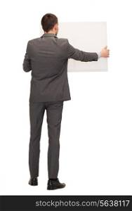 business, education and office concept - businessman or teacher with white big board from back