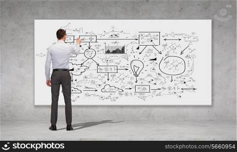 business, education and office people concept - businessman or teacher with marker writing or drawing scheme from back over concrete wall background