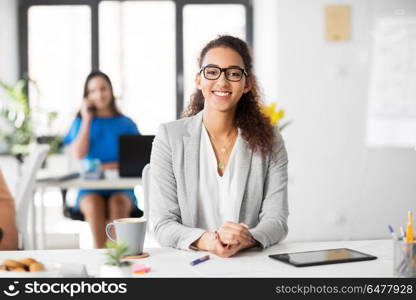 business, education and people concept - happy smiling african american woman in glasses at office. happy smiling african american woman at office. happy smiling african american woman at office