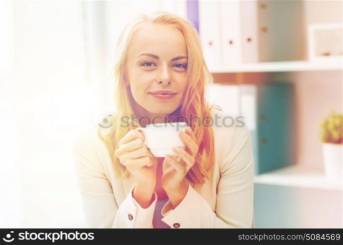 business, education and people concept - happy young businesswoman or student girl drinking coffee at office. happy businesswoman drinking coffee at office. happy businesswoman drinking coffee at office