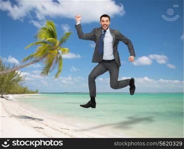 business, education and people concept - smiling happy businessman jumping over tropical beach background