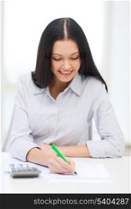 business, education and tax concept - smiling businesswoman or student working with calculator