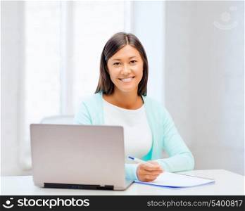 business, education and technology concept - asian businesswoman or student with laptop and documents in office