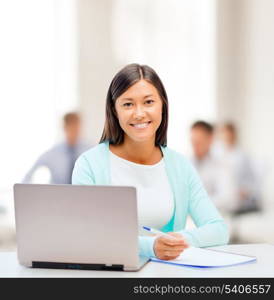 business, education and technology concept - asian businesswoman or student with laptop and documents in office