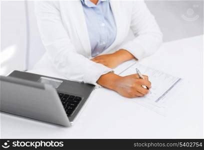 business, education and technology concept - businesswoman with laptop filling a form