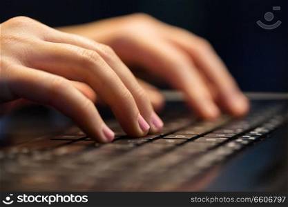 business, education and technology concept - close up of female hands with laptop typing at night. close up of female hands with laptop typing