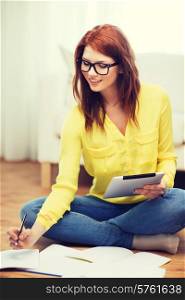 business, education and technology concept - smiling female student in eyeglasses with notebooks and tablet pc computer at home