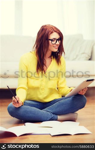 business, education and technology concept - smiling female student in eyeglasses with notebooks and tablet pc computer at home