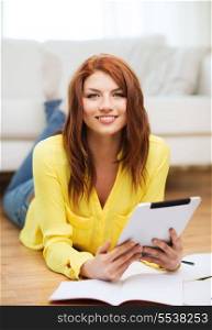 business, education and technology concept - smiling female student with notebooks and tablet pc computer at home