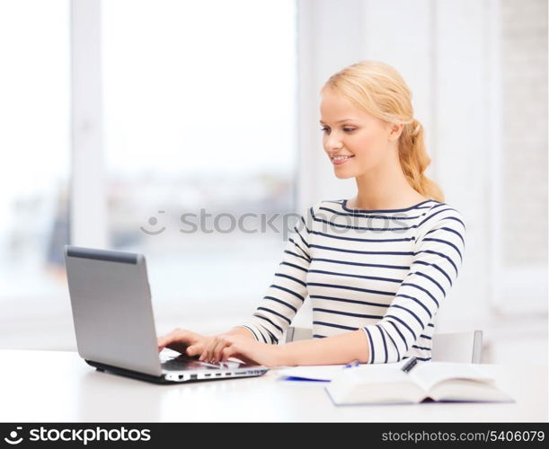 business, education and technology concept - smiling student with book, laptop computer and notebook in college