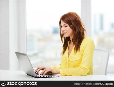 business, education and technology concept - smiling student with book laptop computer at school