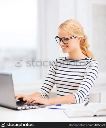 business, education and technology concept - smiling student with laptop book, computer, notebook and black eyeglasses in college