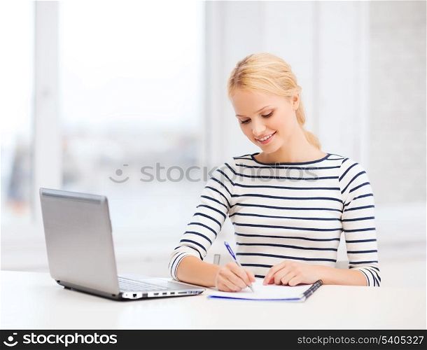 business, education and technology concept - smiling student with laptop computer and notebook in college