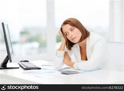 business, education and technology concept - tired businesswoman with computer, papers and calculator at work