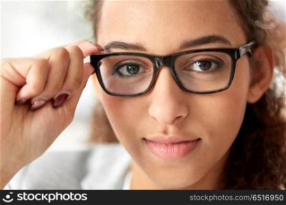 business, education and vision concept - portrait of african american woman in glasses at office. portrait of african american woman in glasses. portrait of african american woman in glasses