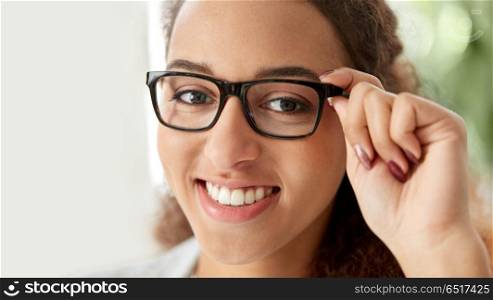 business, education and vision concept - portrait of smiling african american woman in glasses at office. portrait of african american woman in glasses. portrait of african american woman in glasses