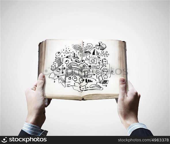 Business education. Close up of male hands holding opened book with sketches