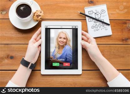 business, education, communication, technology and people concept - close up of woman with incoming call tablet pc computer screen and coffee on wooden table