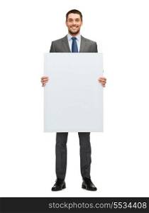 business, education, office and advertising concept - smiling businessman with big white blank board