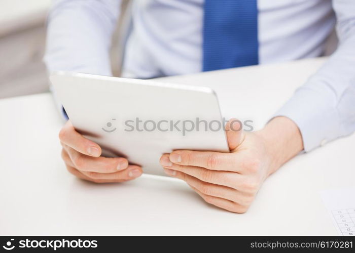 business, education, people and technology concept - close up of businessman with tablet pc in office