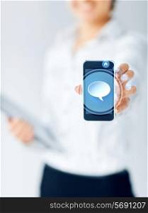 business, education, people and technology concept - close up of businesswoman showing smartphone screen with magnifying glass icon