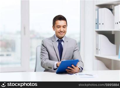 business, education, people and technology concept - smiling businessman with tablet pc computer in office