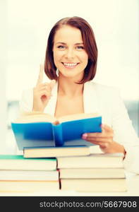 business, education, people concept - smiling businesswoman or student with stack pile of books