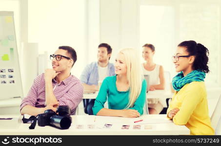 business, education, photography, office and startup concept - smiling creative team with photocamera listening to lecture in office