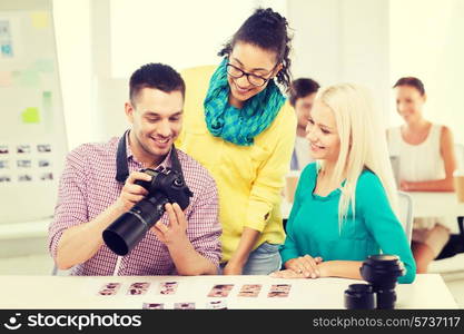 business, education, photography, office and startup concept - smiling creative team with photocamera working in office